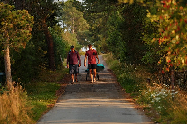 Ung mand med sin pensionerede morfar går med kano på land